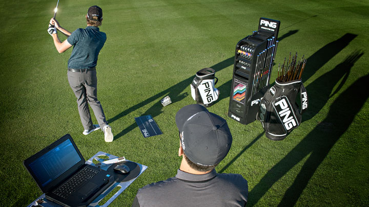 A PING fitter analyzes a golfers shot data on a driving range
